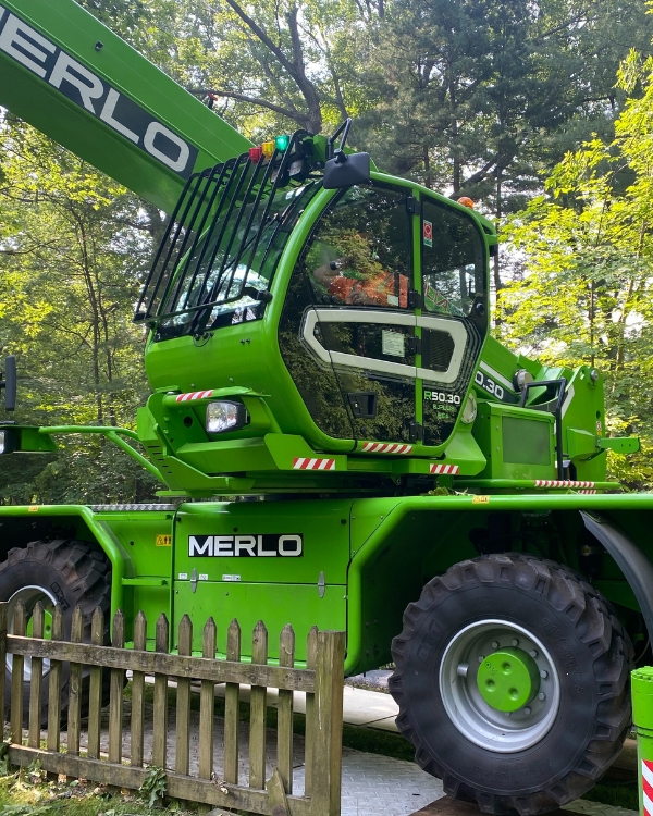 A crane-operator inside a green tree crane of Higher Ground Tree Care doing an emergency tree removal after a storm in Mishawaka, IN.