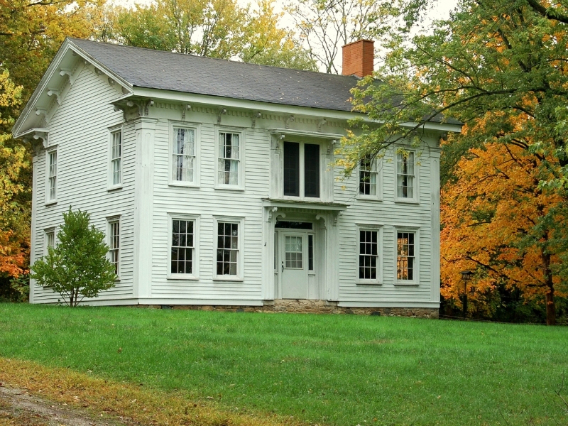 A simple house in Michiana surrounded by trees on a fine fall day.