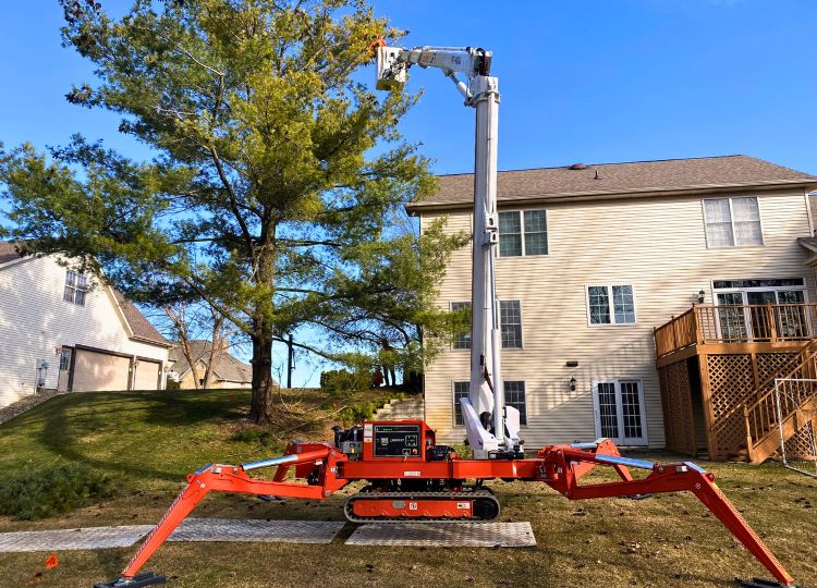 Higher Ground Tree Care using a spider lift to prune a backyard tree in Granger, IN. 