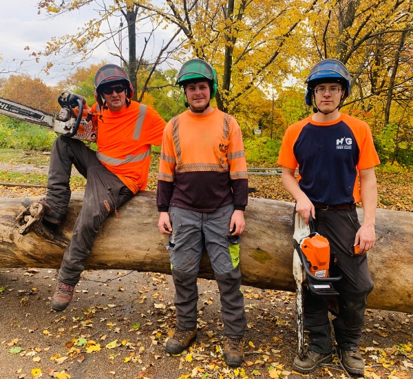 Three arborist posing to the camera after a tree removal on a residence in Michiana.